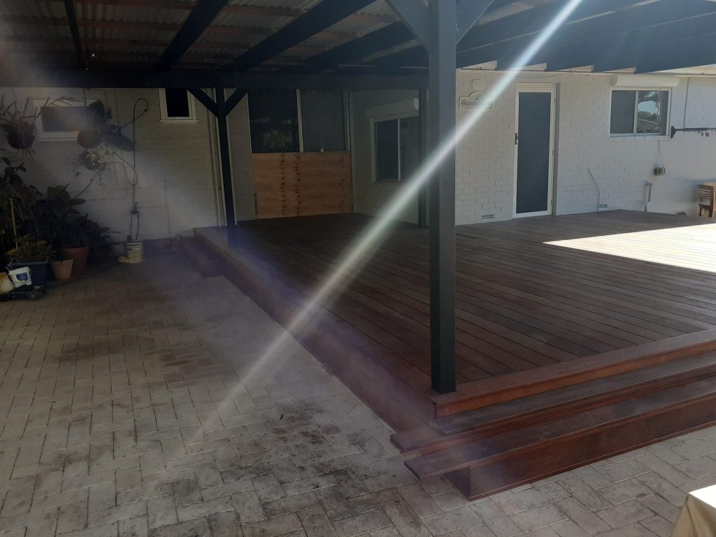 Covered wooden backyard deck with brick paving